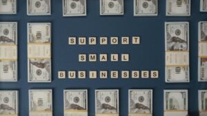 Top view of dollar bills and letter tiles promoting small businesses.