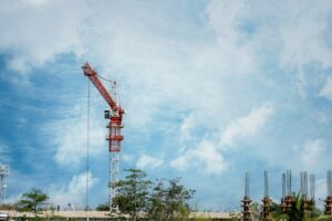 Large business loan for construction project (depicted) with crane against a cloudy blue sky.
