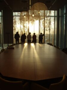 a group of people standing in a room with a large glass door