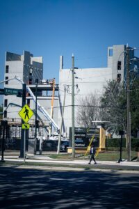 Construction site with unfinished buildings and a lone pedestrian.