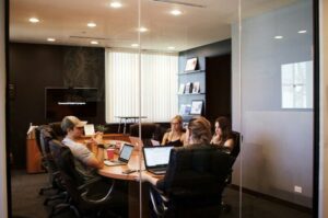 people sitting near table with laptop computer considering private business loans